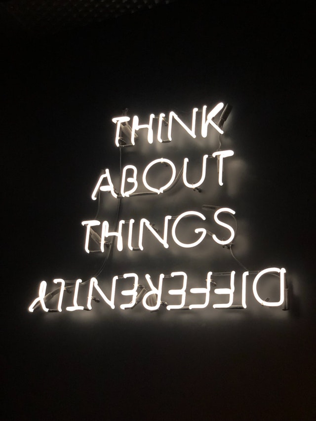 neon sign that says "Think about things differently"