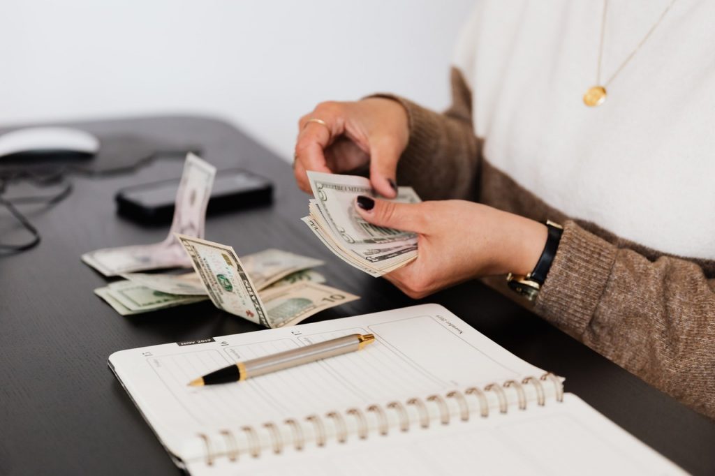cropped picture of woman counting money at a desk
