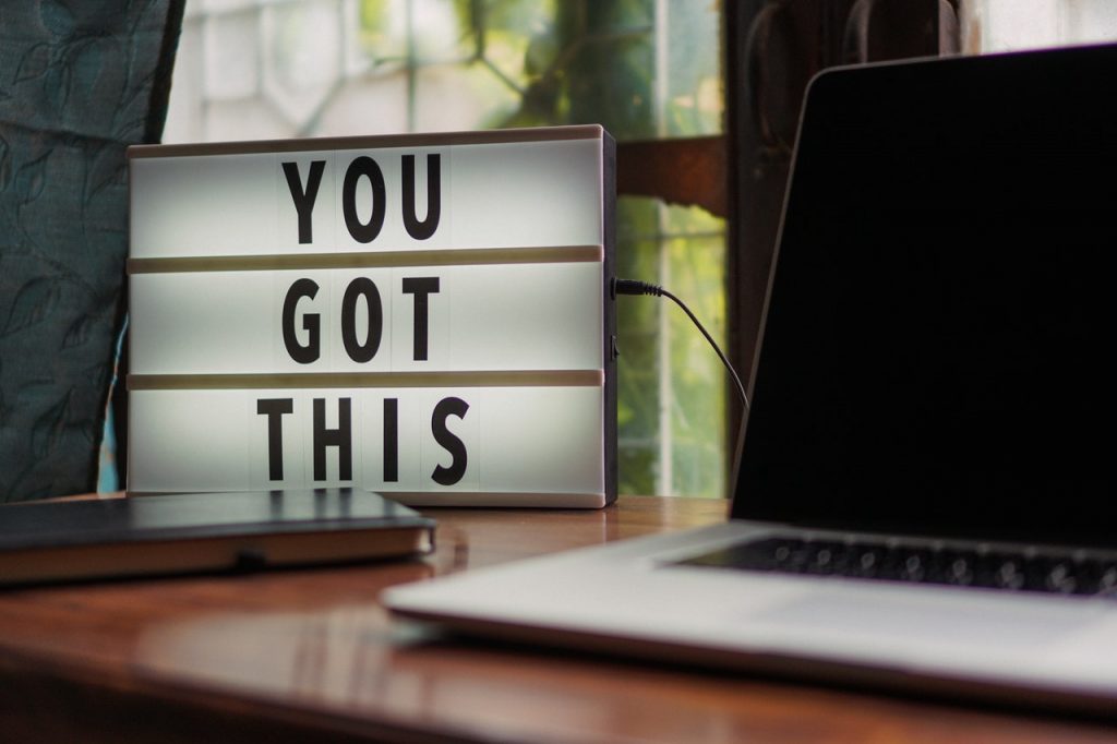 desk with laptop and lighted sign that says "You Got This"