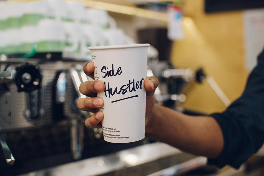Coffee cup with word "side hustle" written on it