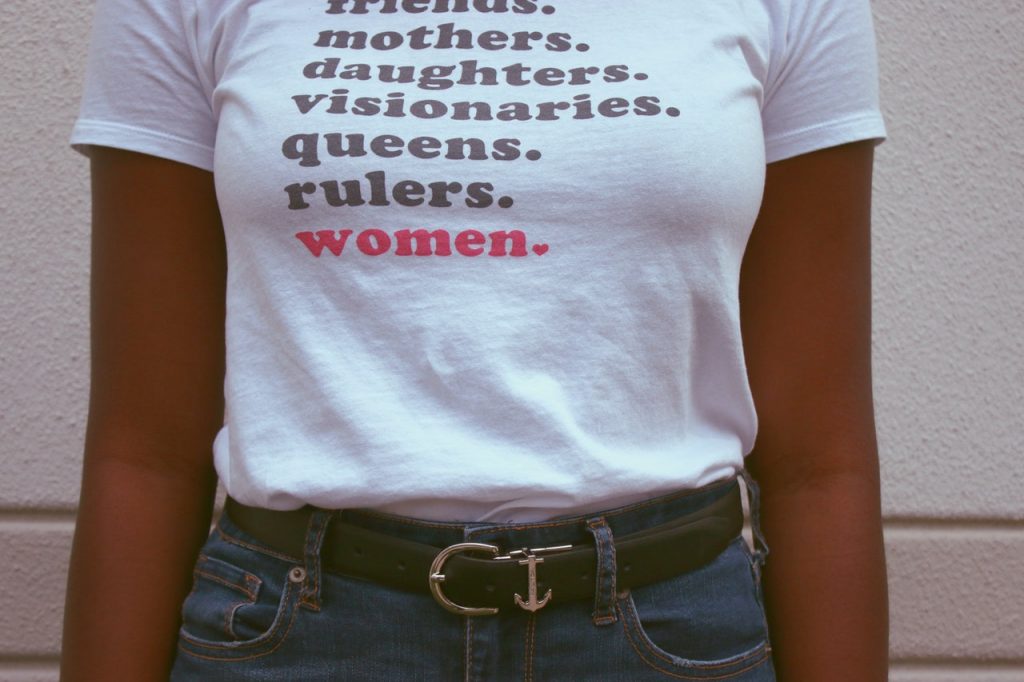 woman wearing t-shirt with words "friends, mothers, daughters, visionaries, queens, rulers, women"